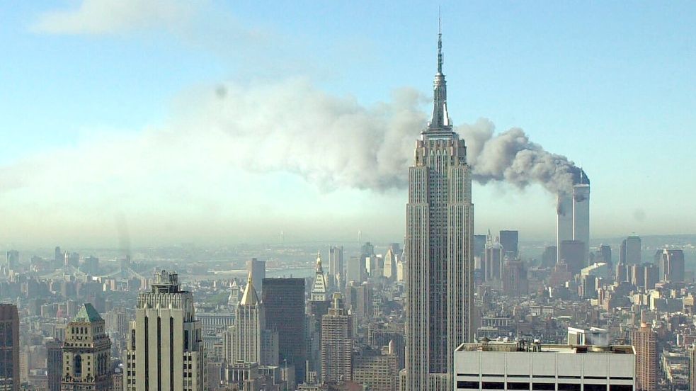 11.09.2001, USA, New York: Rauchschwaden ziehen über die Skyline von New York City, nachdem zwei entführte Flugzeuge in die Zwillingstürme des World Trade Centers geflogen waren. Foto: Patrick Sison/AP/dpa