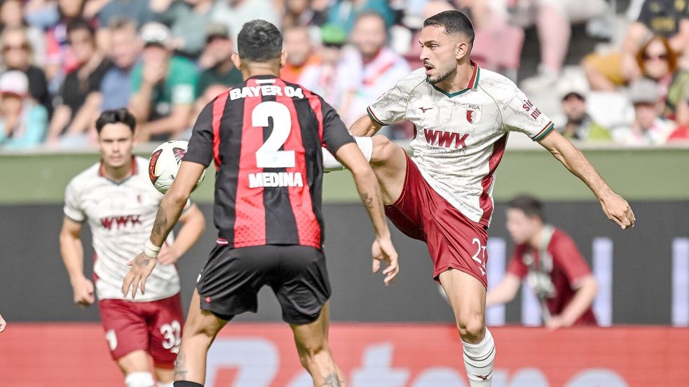 Leverkusens Facundo Medina (links) und Arijon Ibrahimovic vom FC Augsburg kämpfen um den Ball. Foto: Harry Langer