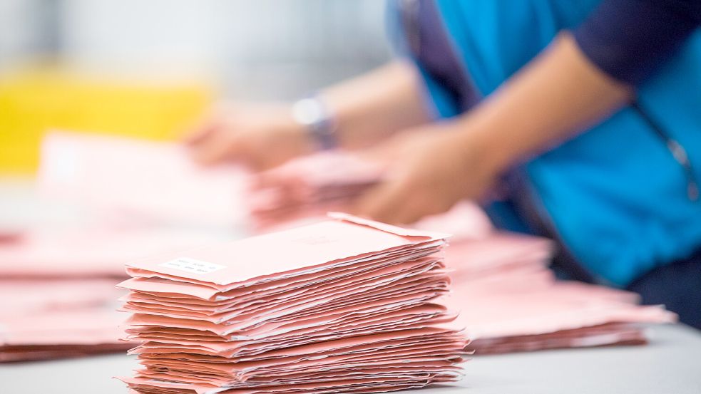 Wahlhelfer sortieren die roten Wahlbriefe mit den abgegebenen Stimmen für die Bundestagswahl 2017. Foto: dpa / Rolf Vennenbernd