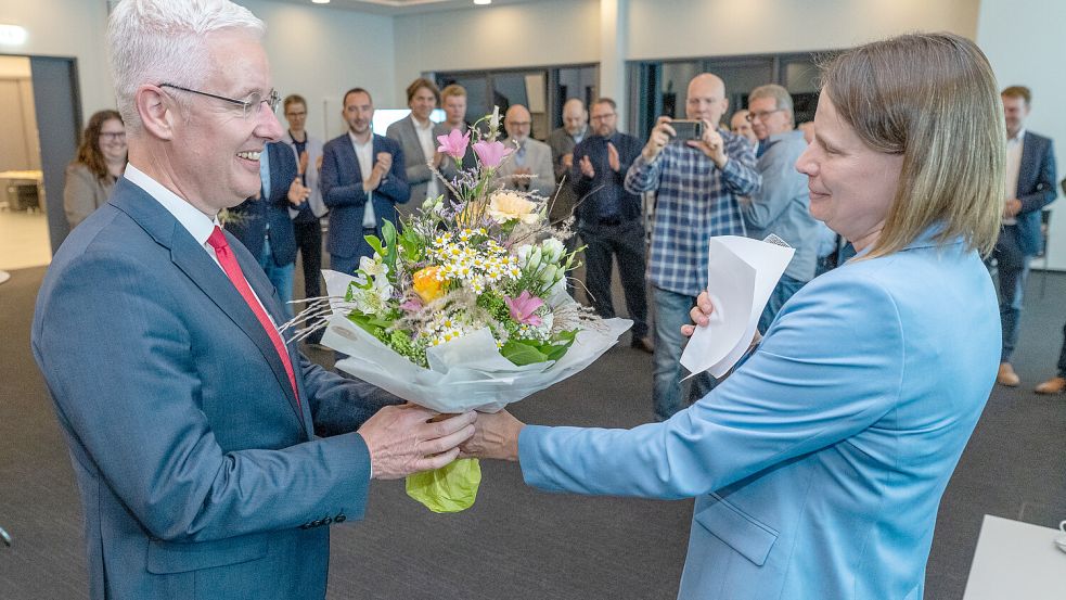 Kreiswahlleiterin Anja Freesemann gratulierte Matthias Groote mit einem Blumenstrauß zur Wiederwahl. Nur noch wenige Kreistagsmitglieder und Zuschauer hatten abgewartet, bis das Ergebnis der Landratswahl feststand. Foto: Klaus Ortgies
