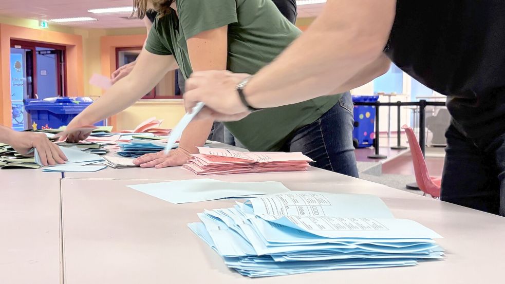 Ein Wahlhelfer sortiert in Ihlow die blauen Stimmzettel für die Ortsratswahlen. Foto: Christin Wetzel