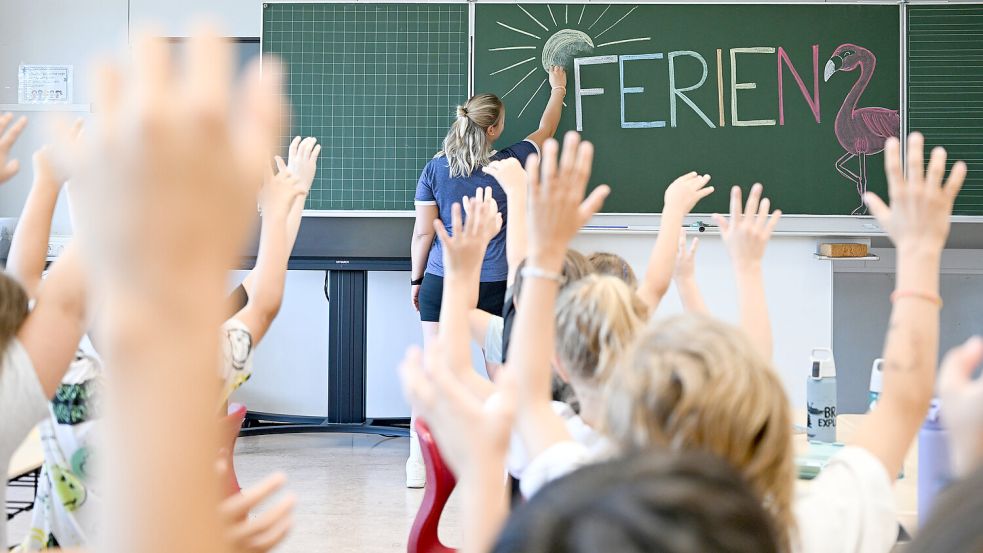 Eine Lehrerin schreibt in diesem Symbolbild das Wort Ferien auf die Tafel. Foto: DPA