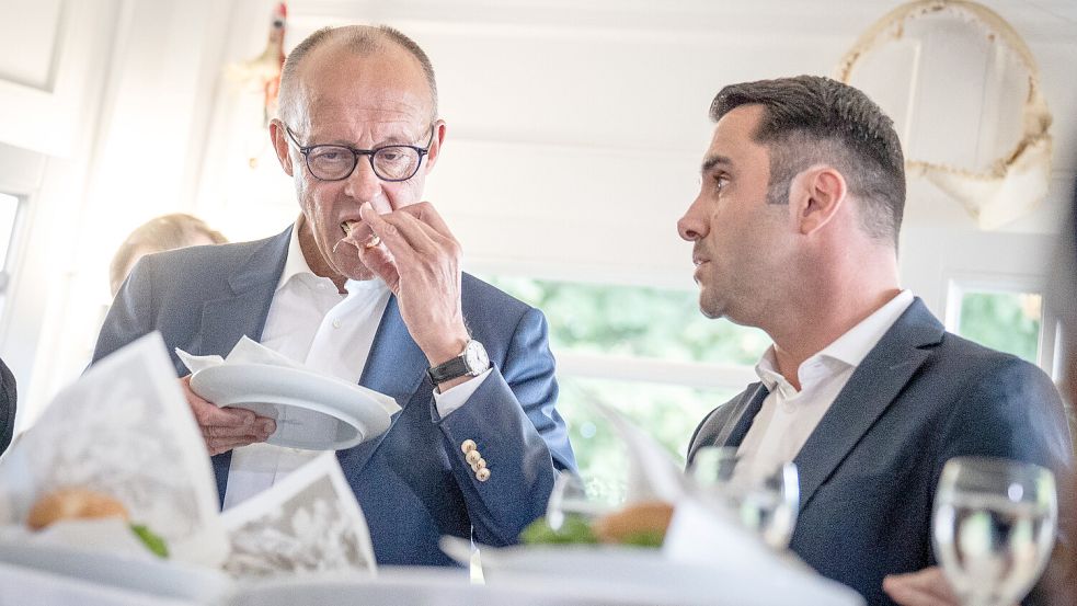 Bangen an der Fünf-Prozent-Hürde: Bundeskanzler Friedrich Merz isst ein Fischbrötchen mit Daniel Peters, CDU-Spitzenkandidat im Wahlkampf in Mecklenburg-Vorpommern. Foto: IMAGO/Chris Emil Janssen
