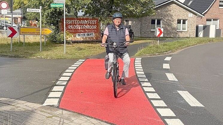 Bernhard Robbers fährt im Bereich der Mühlenstraße in Langholt über die neue Rotmarkierung auf der Radfurt. Der Ehrenortsbürgermeister hatte sich lange für eine bessere Sichtbarkeit der Querungen eingesetzt. Foto: Horst Kruse