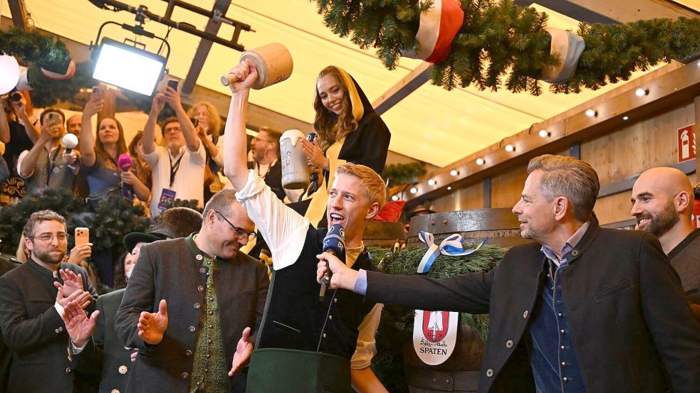 Dominik Krause (M, Bündnis 90/Die Grünen), Oberbürgermeister von München, beim traditionellen Anstich des ersten Bierfasses im Schottenhamel. Foto: Sven Hoppe/dpa