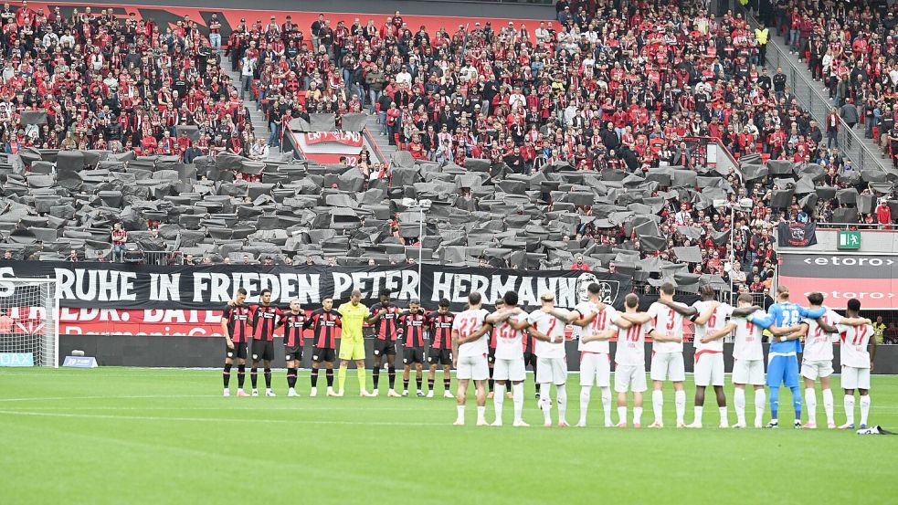 Die Spieler von Bayer Leverkusen und RB Leipzig gedachten Peter Hermann vor der Partie mit einer Schweigeminute.  Foto: Federico Gambarini/dpa