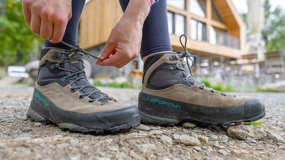 Eine Frau schnürt ihre Wanderschuhe. Deutschland gilt mit seinen vielfältigen Landschaften und Regionen als Wanderland.  Foto: Hendrik Schmidt/dpa