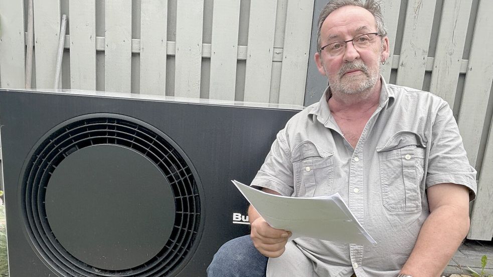 Harald Ziegler aus Holtermoor sitzt neben der Wärmepumpe, deren staatliche Förderung nach seiner Darstellung bei der Berechnung seines Wohngeldes als Einkommen angerechnet wurde. Dieses sei unzulässig, kritisiert er. Foto: Henrik Zein