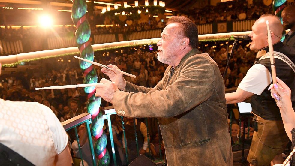 „Terminator“ Arnold Schwarzenegger dirigiert im Marstall-Festzelt. Foto: Felix Hörhager/dpa