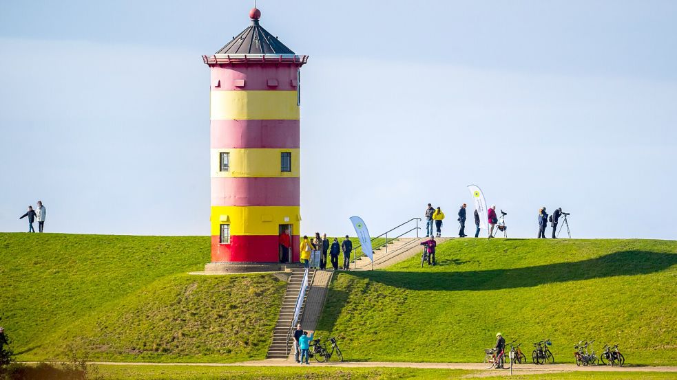 Spaziergänger am Pilsumer Leuchtturm an der Nordseeküste können am Wochenende noch einmal viel Sonnenschein genießen. Foto: dpa/Sina Schuldt