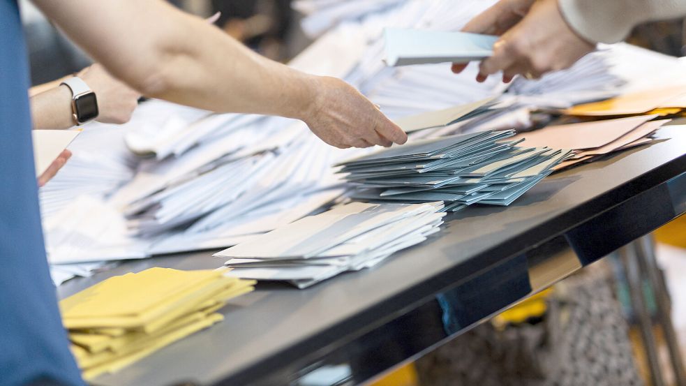 Wahlhelfer sortieren die Stimmzettel für die Auszählung der Briefwahl. In Leer gab es bei der Ausgabe der Stimmzettel einen Fehler. Symbolfoto: Michael Matthey/dpa