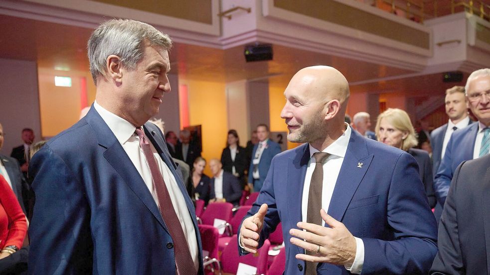 Sport-Staatsminister Ronald Rauhe (r) sprach vor Beginn der Wahl-Versammlung mit dem bayerischen Ministerpräsidenten Markus Söder (CSU). Foto: Marijan Murat/dpa