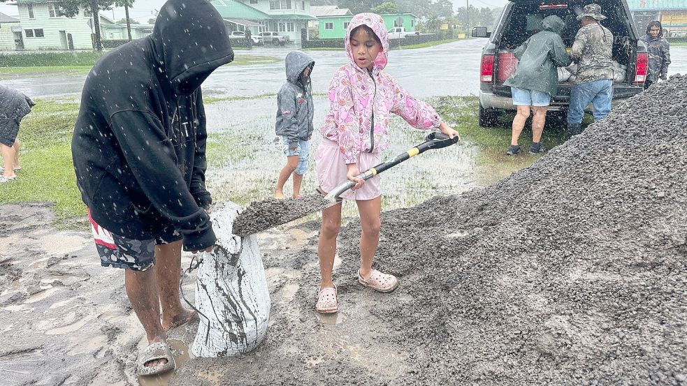 In Hawaii füllen Menschen Sandsäcke, um ihre Häuser vor den Auswirkungen von „Nolo“ zu schützen. Foto: Eugene Garcia/AP/dpa