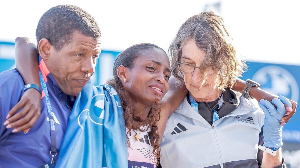 Tigst Assefa musste mit Tränen in den Augen von Lauf-Legende und ihrem Trainer Haile Gebrselassie im Ziel gestützt werden. Foto: Andreas Gora/dpa