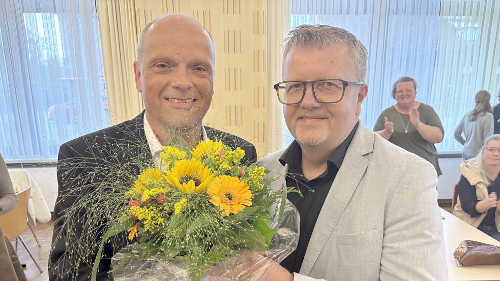 Westoverledingens Bürgermeister Theo Douwes (rechts) gratulierte seinem Nachfolger Michael Ulrichs zur Wahl zum neuen Bürgermeister und überreichte einen Blumenstrauß. Ulrichs tritt sein neues Amt am 1. November offiziell an. Foto: Carsten Ammermann