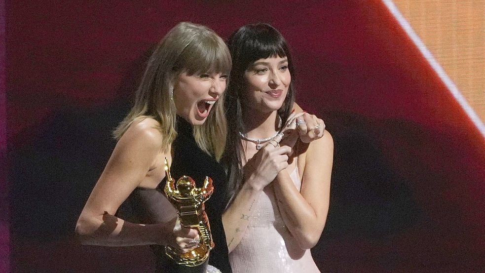 Dakota Johnson überreicht Taylor Swift den Sonderpreis.  Foto: Chris Pizzello/Invision/AP/dpa