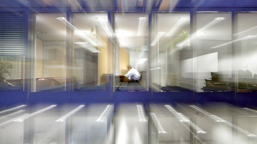 Ein Arbeitnehmer im abendlichen Büro. Die Identifikation mit dem Beruf nimmt laut einer neuen Umfrage ab. (Symbolbild) Foto: Frank Rumpenhorst/dpa