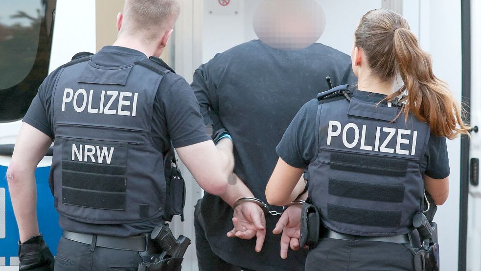 Ein Mann aus dem Umfeld der „Hells Angels“ wird in Duisburg abgeführt. Foto: Christoph Reichwein/dpa