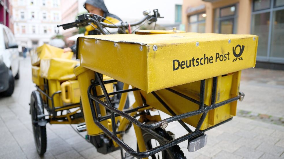 Eine Postbotin bei der Arbeit.  Foto: Philip Dulian/dpa