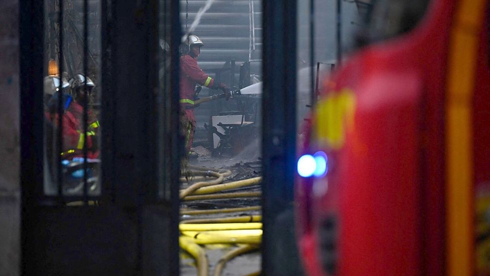Die Feuerwehr brachte den Brand in der Markthalle unter Kontrolle. Foto: Julien De Rosa/AFP/dpa