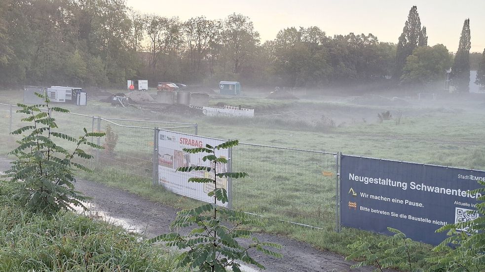 Ein Schild am Bauzaun beim Schwanenteich-Areal in Emden weist auf die aktuelle Baupause hin. Derzeit laufen Kampfmittel-Sondierungen. Foto: Mona Hanssen