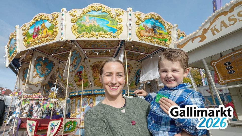 Vivien Grimmer und ihr Sohn Maximilian stehen vor dem Pferdekarussell, das auf dem Gallimarkt in Leer viele Blicke auf sich zieht. Foto: Klaus Ortgies