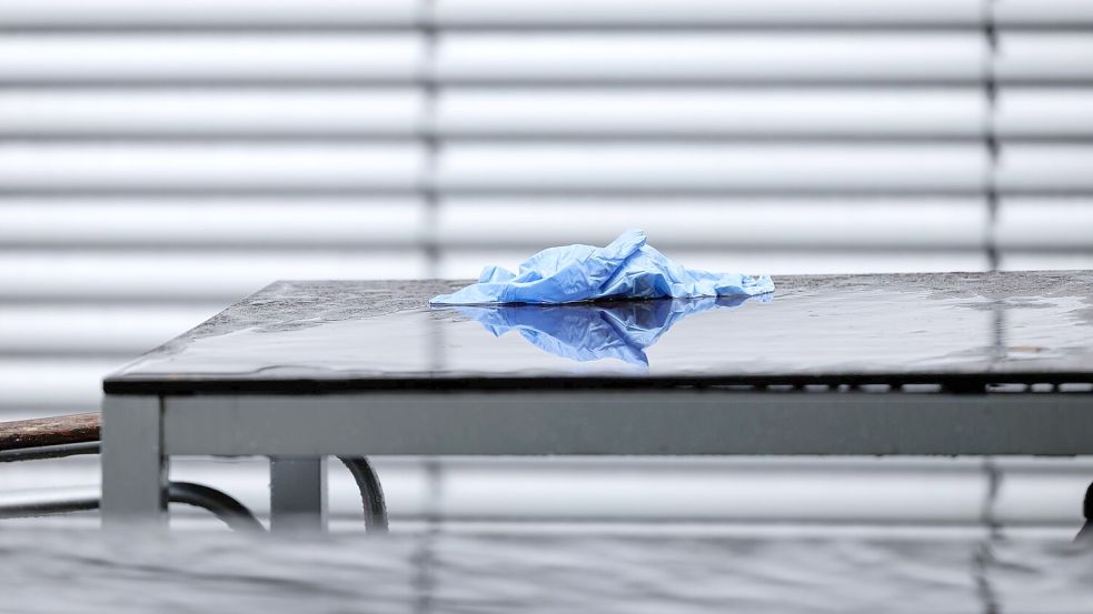 Einweghandschuhe liegen auf einem Tisch - Ermittler waren lange in der Einrichtung zugange. Foto: David Ebener/dpa