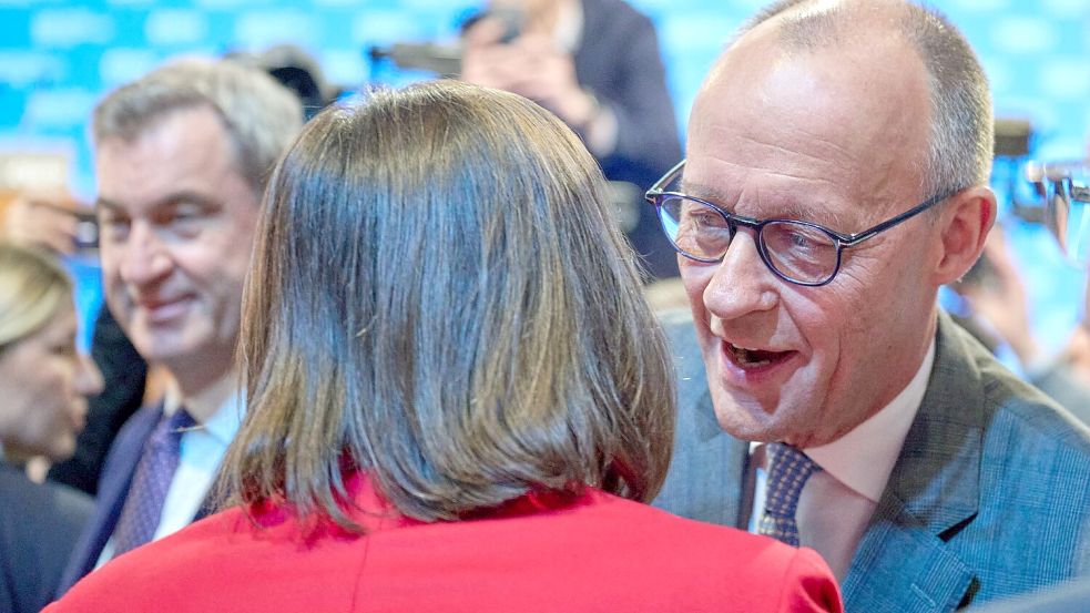 Friedrich Merz begrüßt Ilse Aigner mit Wangenküsschen. Foto: Peter Kneffel/dpa