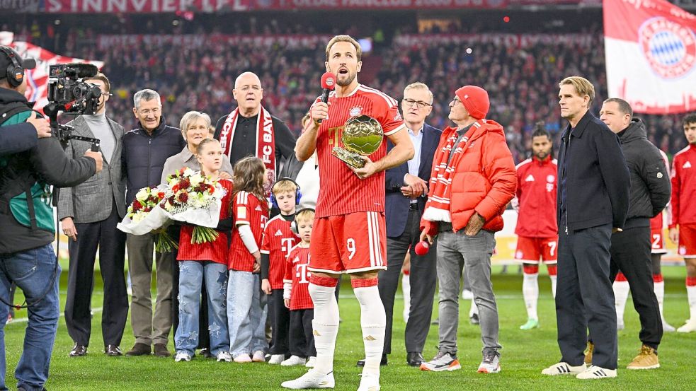 Harry Kane mit dem Ballon d’Or, im Hintergrund seine Familie. Foto: Tom Weller/dpa